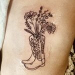 a tattoo of a cowboy boot with flowers