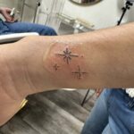 fine line wrist tattoo with stars